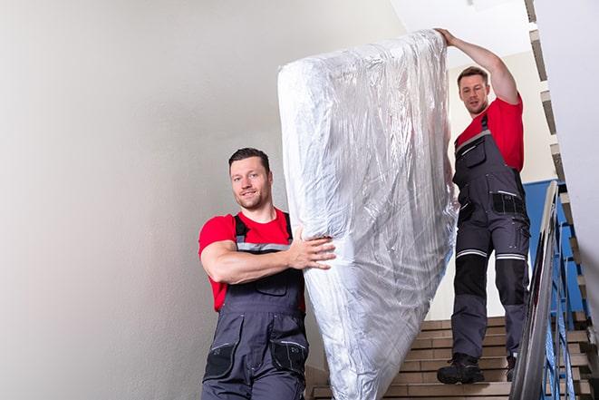 two people disposing of box spring from bedroom in Basin City